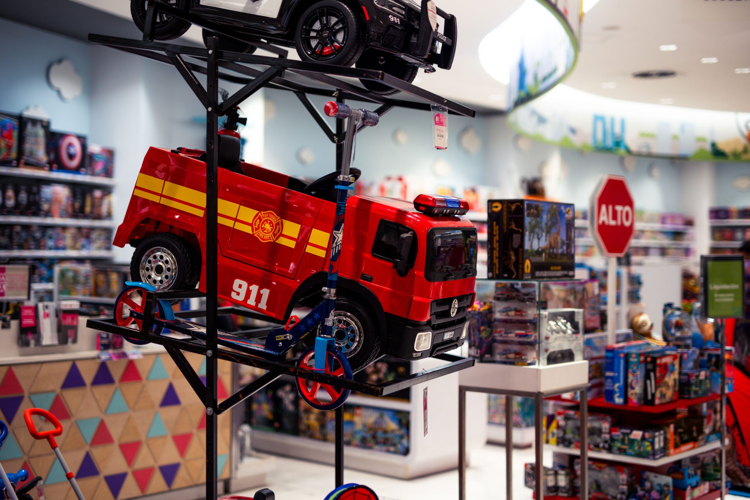 Toy store display with a red fire truck and colorful toys.